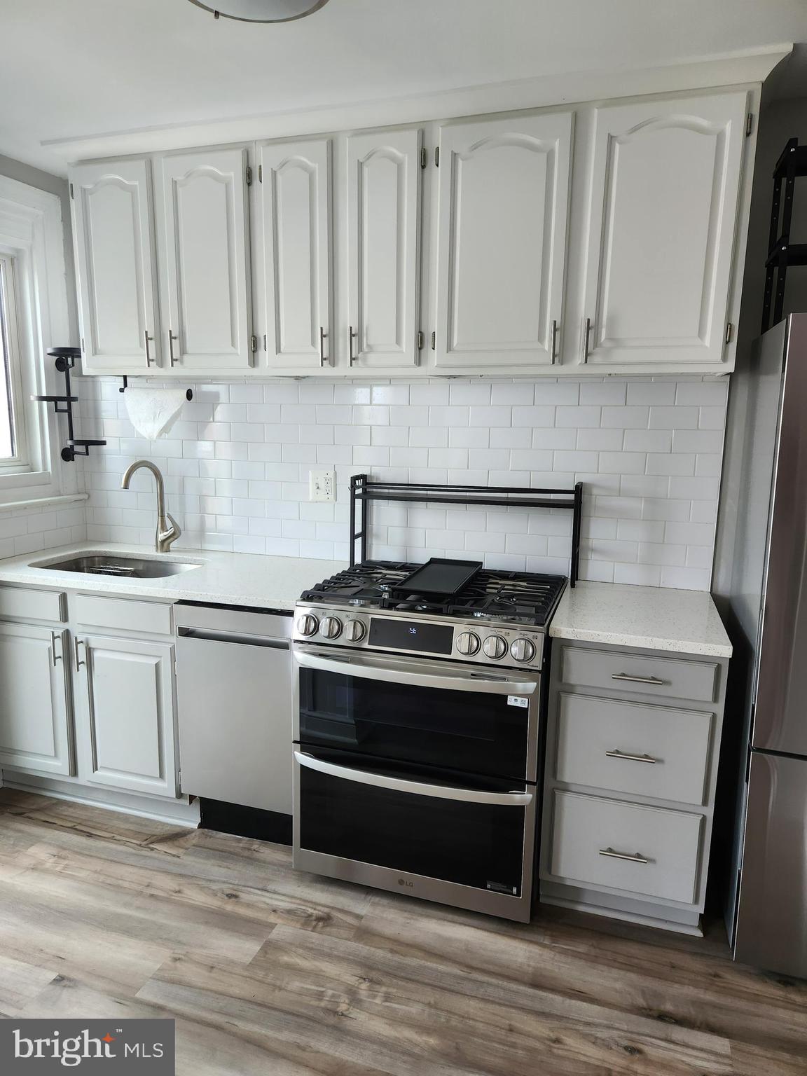 1702 Lang Place Northeast Washington, DC 20002 - Photo 14 of 36 a kitchen with white cabinets and appliances