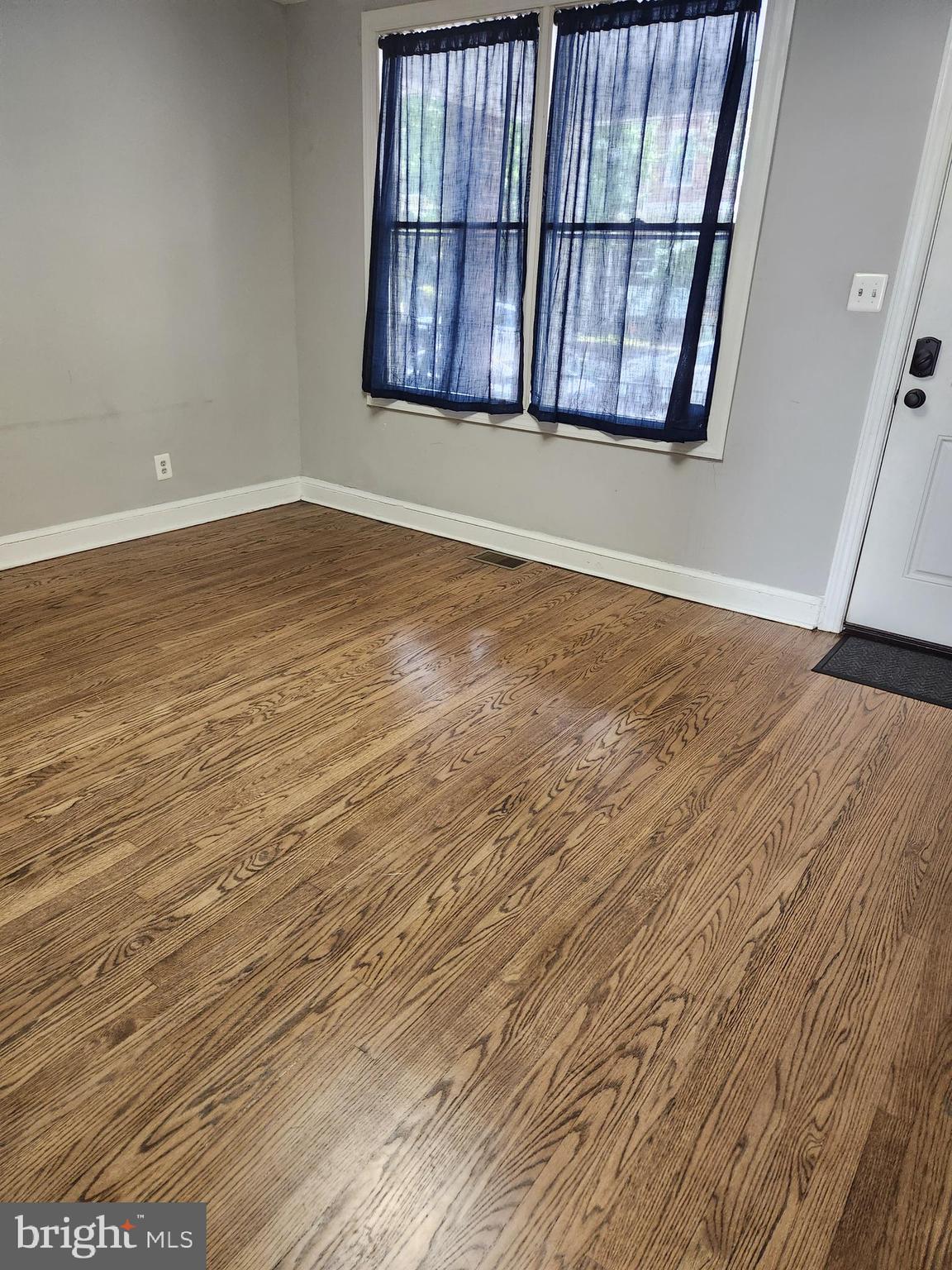 1702 Lang Place Northeast Washington, DC 20002 - Photo 3 of 36 an empty room with wooden floor and windows