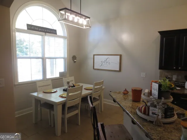 a view of a dining room with furniture a chandelier and a window