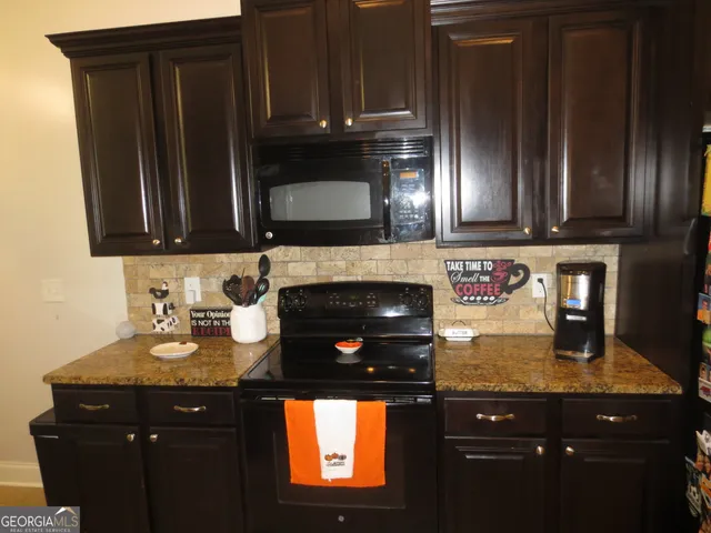 a kitchen with granite countertop stainless steel appliances wooden cabinets and a sink