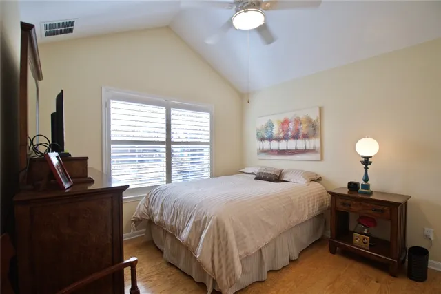 a bedroom with a bed and a flat tv screen on dresser
