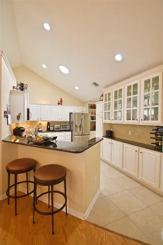 a kitchen with stainless steel appliances granite countertop a stove a sink a dining table and chairs