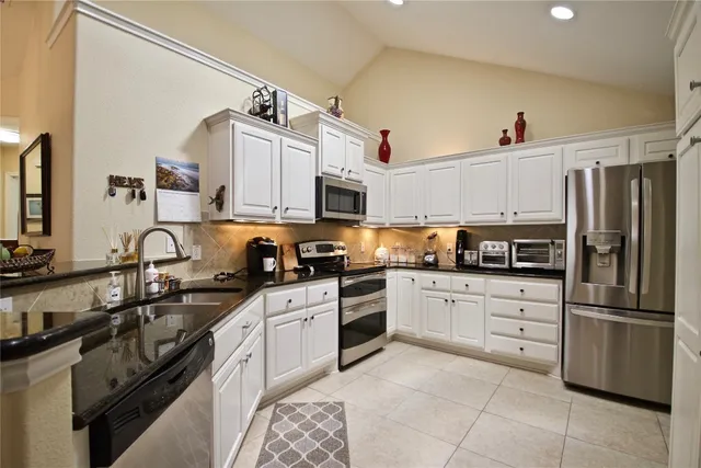 a kitchen with stainless steel appliances granite countertop a sink and cabinets
