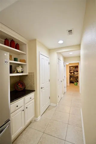 a hallway with cabinets and dresser