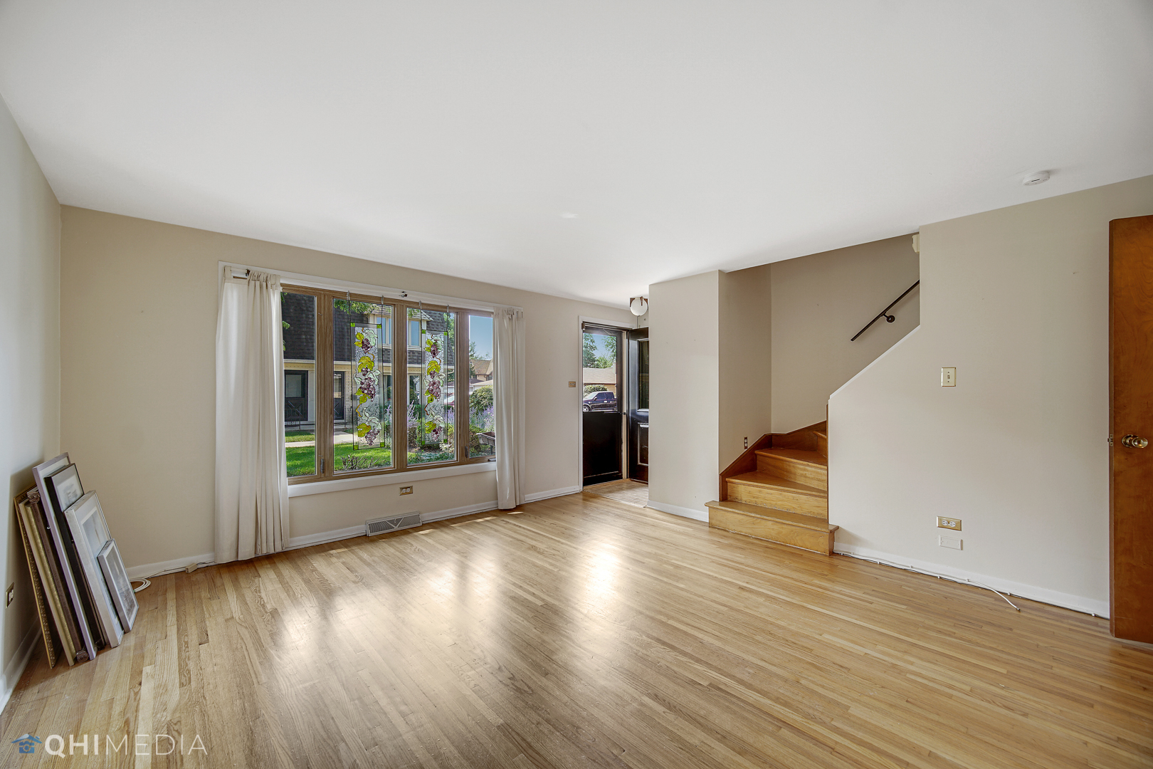 2128 West 111th Street, Unit G Chicago, IL 60643 - Photo 5 of 20 a view of an empty room with wooden floor and a window