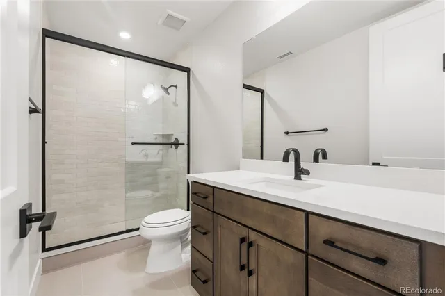 a bathroom with a sink a toilet and a large mirror
