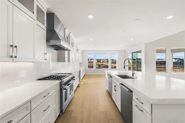 a large kitchen with stainless steel appliances kitchen island granite countertop a stove and a sink