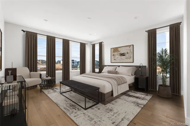 a bedroom with a large bed couch and a large window