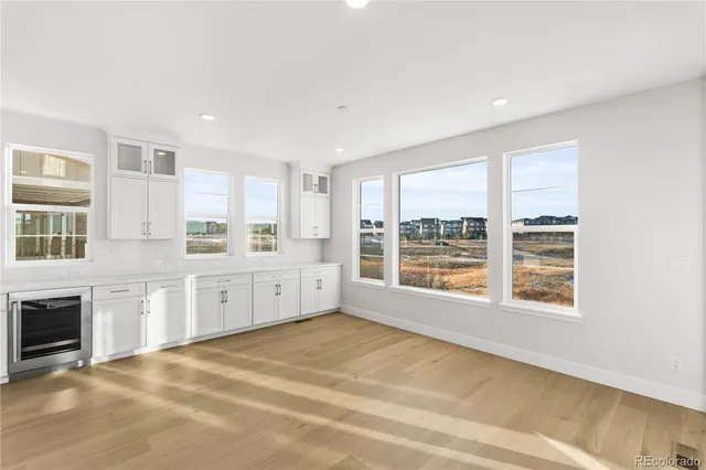 a large white kitchen with granite countertop a stove a sink dishwasher and a microwave oven with white cabinets