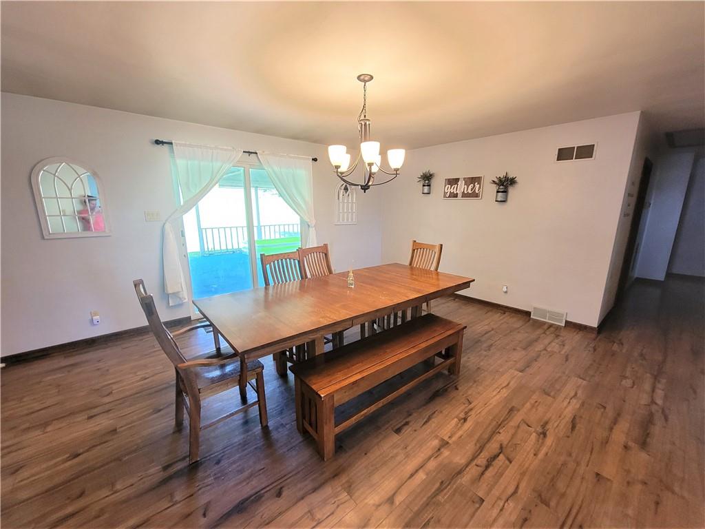 130 Pflugh Road Butler, PA 16001 - Photo 5 of 25 a dining room with wooden floor a chandelier a wooden table and chairs