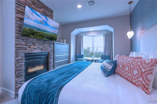 a spacious bedroom with a bed and a fireplace