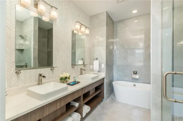 a bathroom with a bathtub shower sink double and mirror