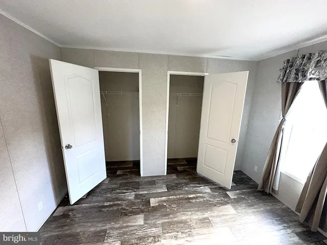 a view of a bedroom with wooden floor and a window