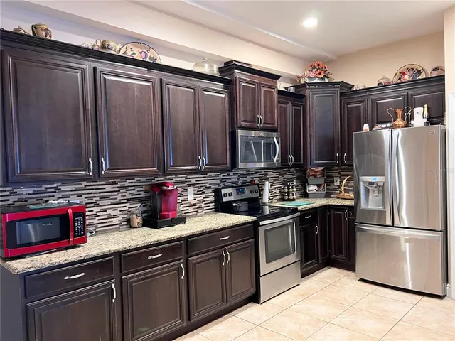 a kitchen with stainless steel appliances granite countertop a refrigerator and a sink