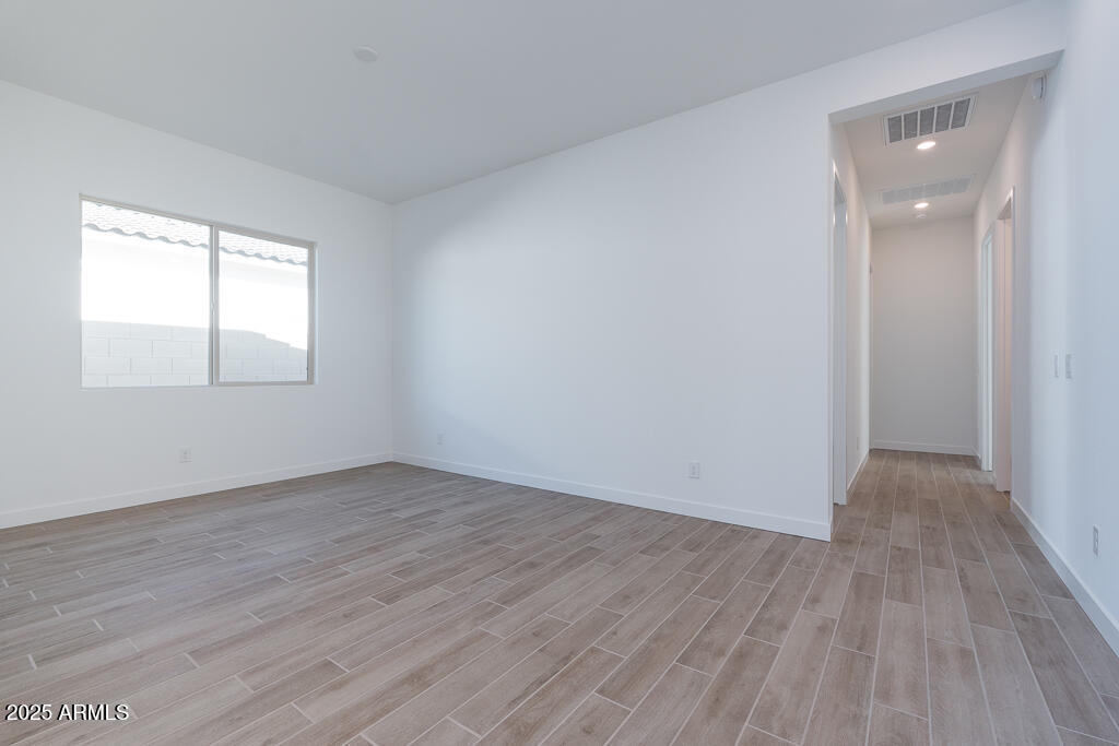 816 Golden Ore Pass Apache Junction, AZ 85120 - Photo 12 of 23 an empty room with wooden floor and windows