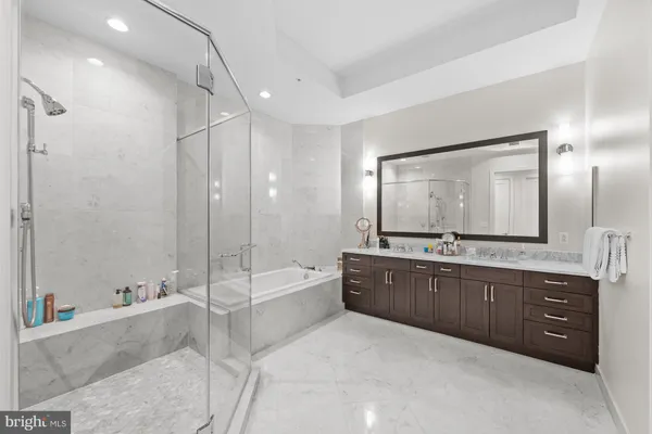 a spacious bathroom with a tub sink shower and mirror