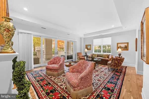 a living room with furniture large windows and wooden floor