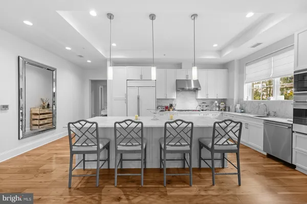 a kitchen with stainless steel appliances granite countertop a dining table chairs sink and cabinets