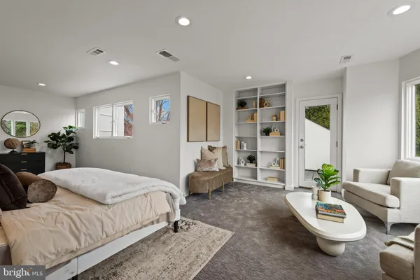 a spacious bedroom with a bed a couch and a potted plant