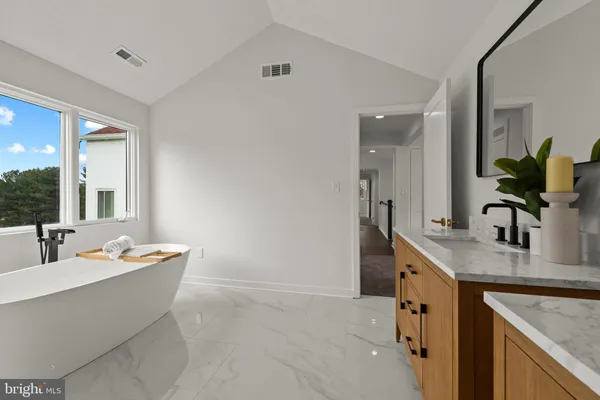 a bathroom with a granite countertop sink a mirror and shower