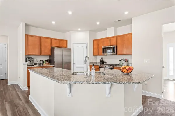 a kitchen with stainless steel appliances granite countertop a sink a stove and a refrigerator