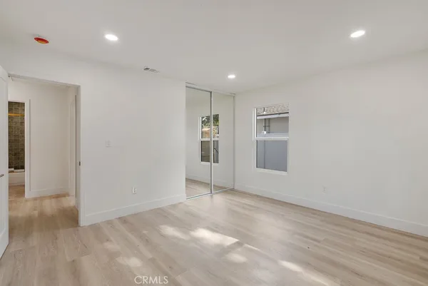 a view of an empty room with closet and a window