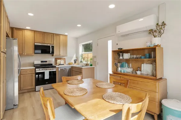 a kitchen with stainless steel appliances granite countertop a stove a sink a microwave a dining table and chairs