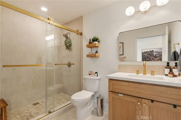 a bathroom with a sink a toilet and shower