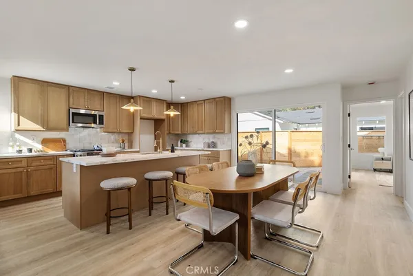a kitchen with a dining table chairs refrigerator and cabinets