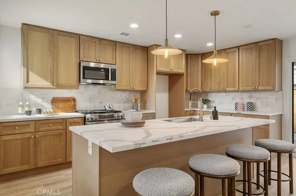 a kitchen with a dining table chairs microwave and cabinets