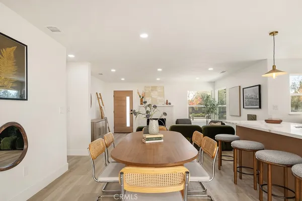a living room with furniture a rug and kitchen view