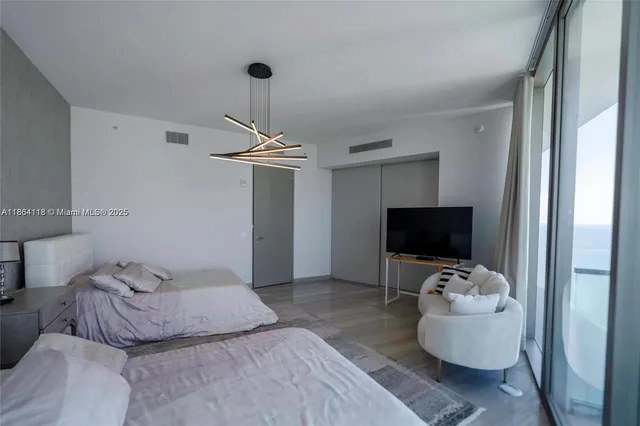 a bedroom with furniture and a flat screen tv