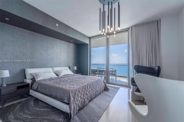 a bedroom with a bed window and a chandelier