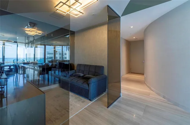 a living room with couches and kitchen view with wooden floor