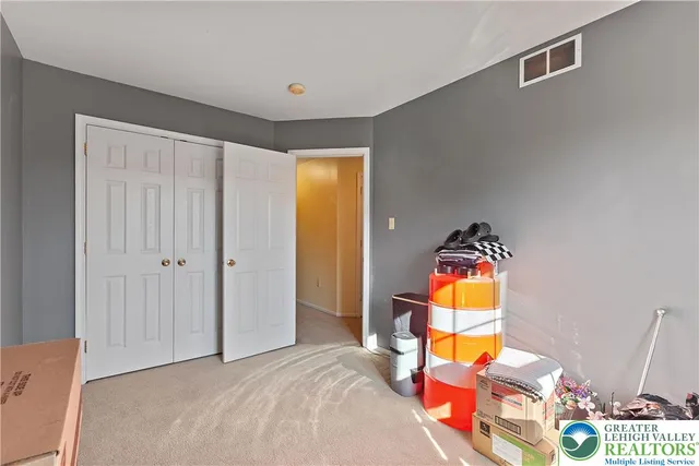 a bedroom with a bed and a flat tv screen on the dresser