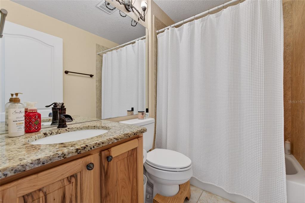 1864 Orange Tree Drive Edgewater, FL 32141 - Photo 35 of 38 a bathroom with a granite countertop sink and a mirror