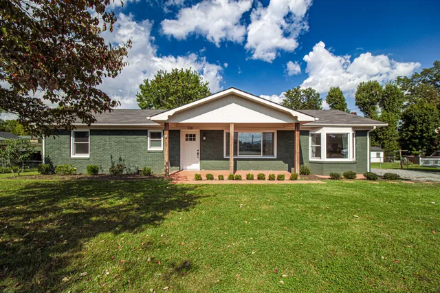 a front view of a house with a garden