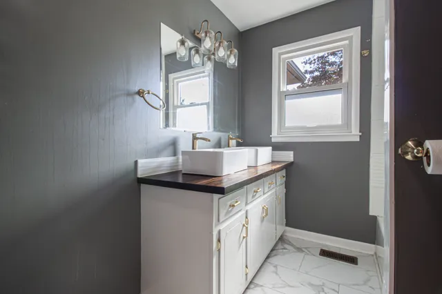 a bathroom with a granite countertop sink a mirror and window