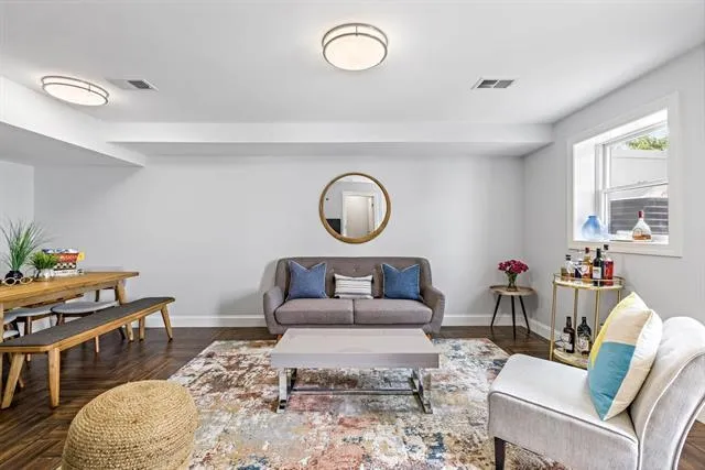 a living room with furniture and a wooden floor