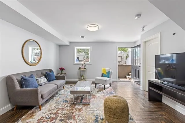 a living room with furniture a rug and a flat screen tv