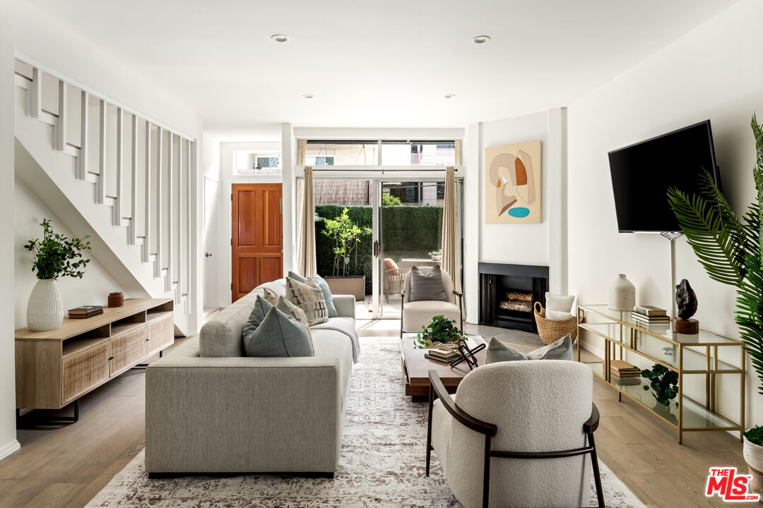 a living room with furniture a flat screen tv and a fireplace