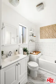 a bathroom with a toilet a sink a mirror a bathtub and shower