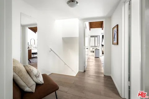 a view of a hallway with wooden floor and furniture