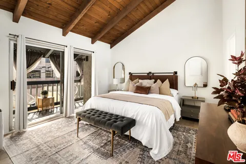 a bedroom with bed and wooden floor