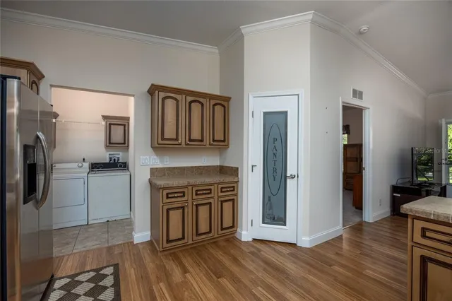a view of a kitchen with a sink stove refrigerator and cabinets