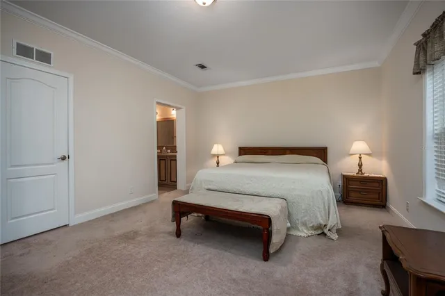 a spacious bedroom with a bed and a lamp