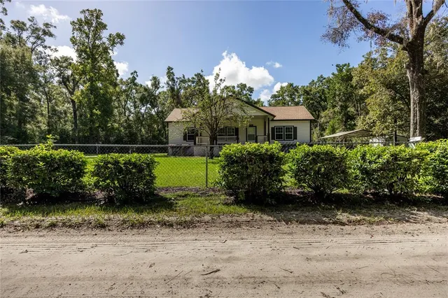 a front view of a house with a yard and potted plants