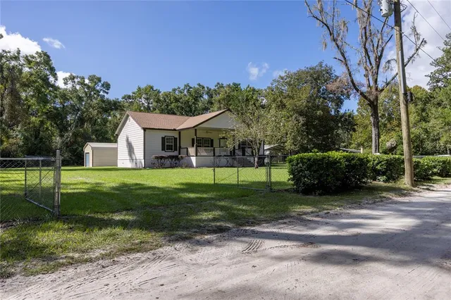 a view of a house with backyard and a tree