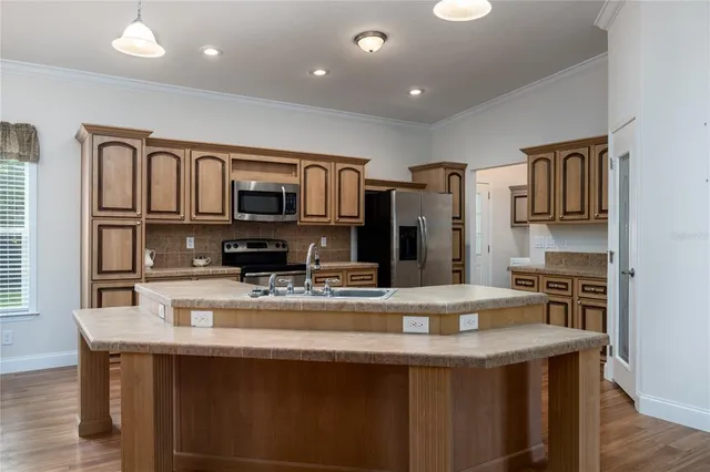 a kitchen with stainless steel appliances granite countertop a stove refrigerator sink and microwave