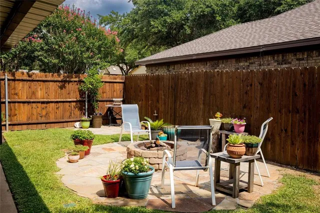 a view of a patio with table and chairs potted plants with wooden fence